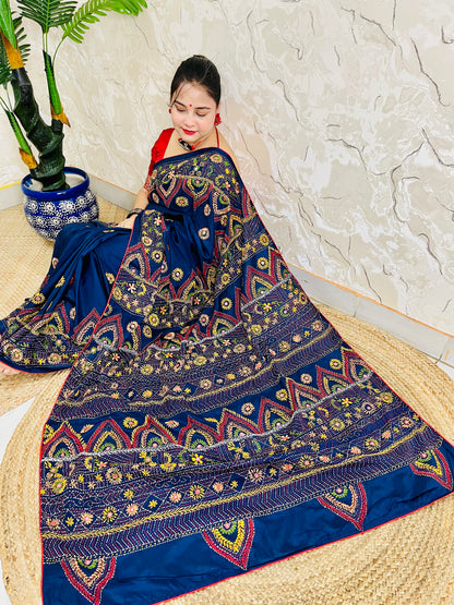 Woman seated in deep indigo Bangalore silk saree with Lambani hand embroidery