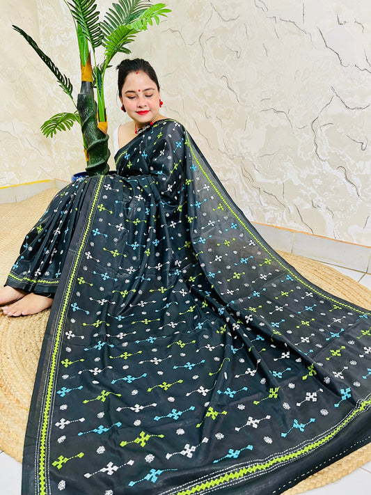 Woman seated wearing black Kutch embroidery saree, Bangalore silk fabric detail