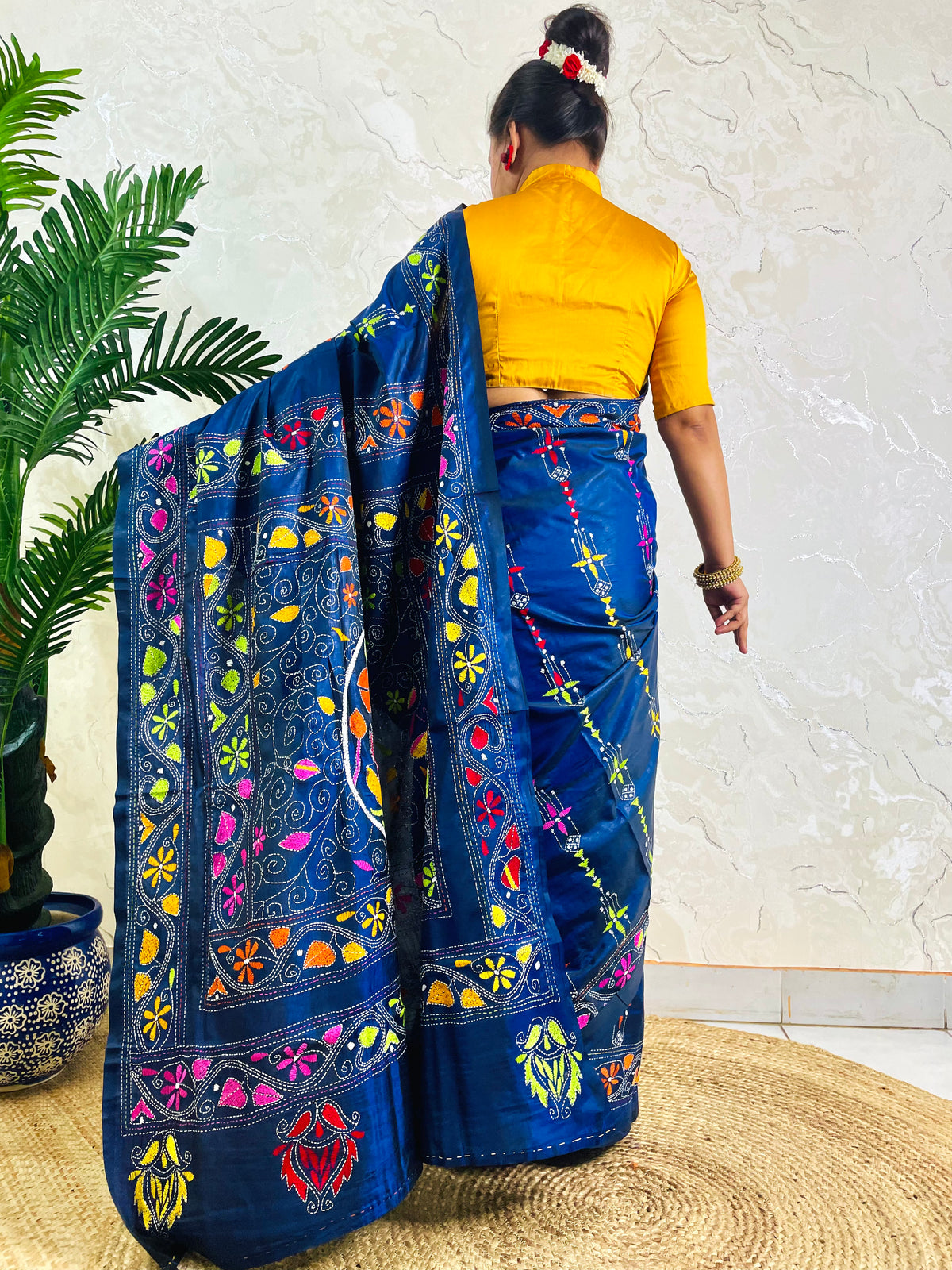 Back standing view of ink blue Kantha stitch saree with swan and floral border