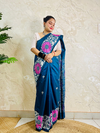 Pallu held open showing rows of magenta sunflowers and white leaf vines on peacock blue saree