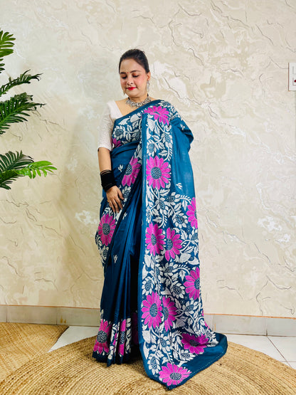 Pallu held open showing rows of magenta sunflowers and white leaf vines on peacock blue saree