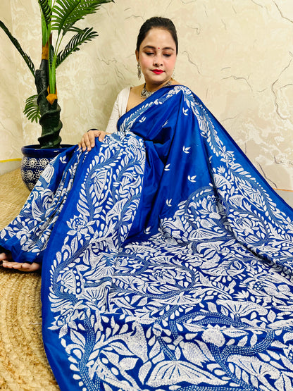Seated close view of royal blue Kantha stitch saree pallu with dense white leaf work