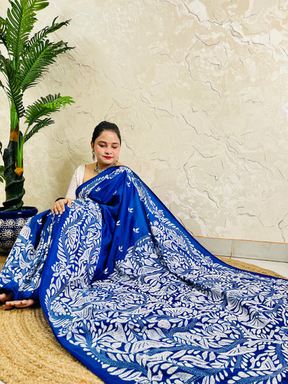 Seated drape of royal blue Kantha saree spread out showing looping branch and lotus-like bloom embroidery