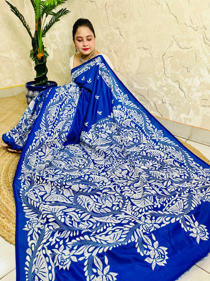 Seated close view of royal blue Kantha stitch saree pallu with dense white leaf work