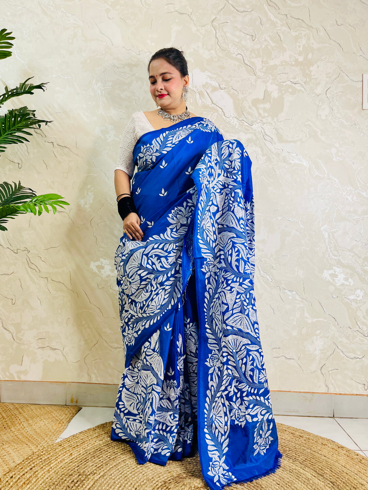 Front standing view of royal blue Kantha saree with branch and leaf pallu and plain body