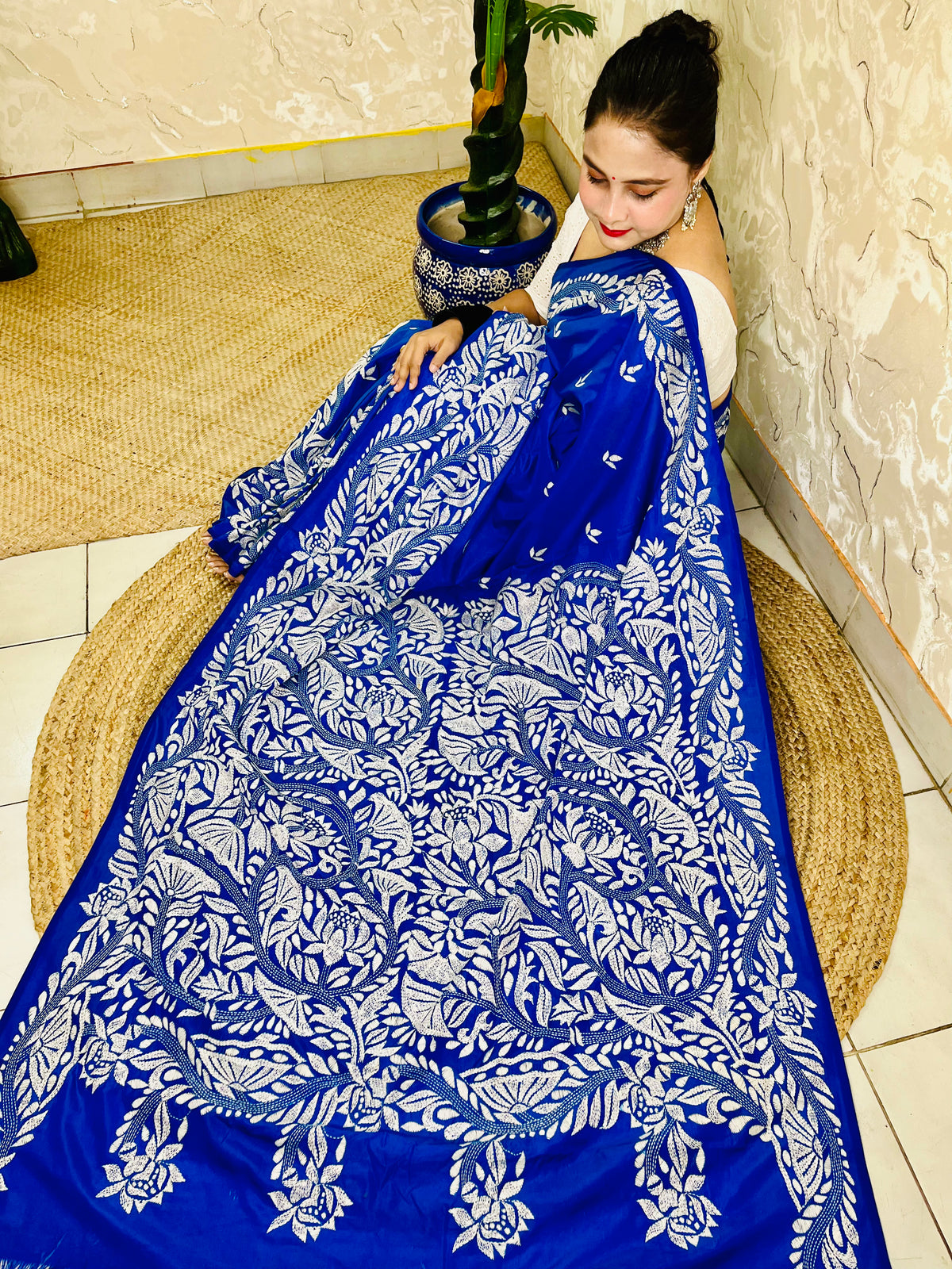 Seated close view of royal blue Kantha stitch saree pallu with dense white leaf work