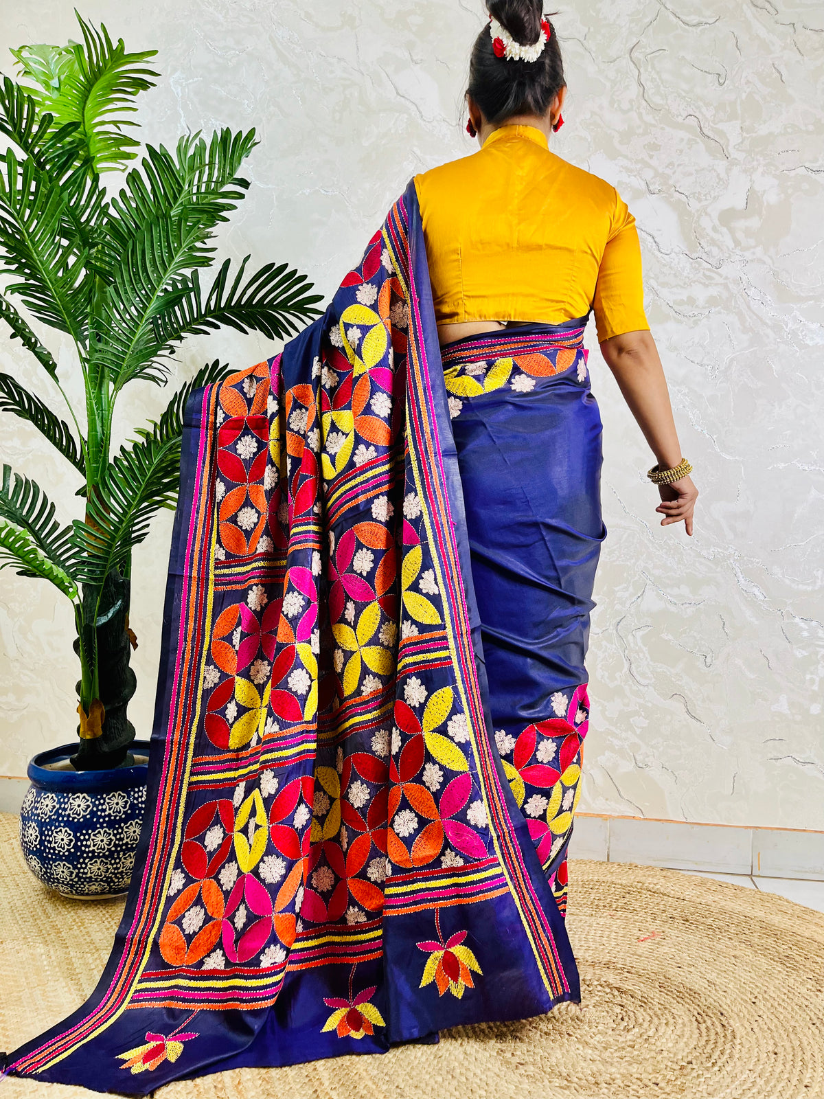 Deep indigo blue Kantha stitch saree with geometric pinwheel pattern, back standing view
