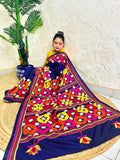 Woman seated in deep indigo Kantha saree with multicolour geometric border, side view