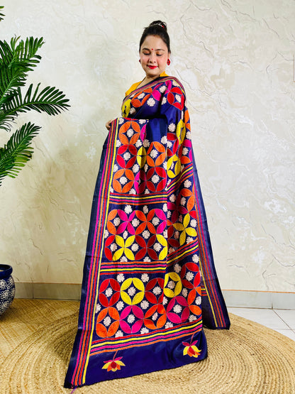 Woman draping deep indigo Kantha stitch saree, pallu spread standing view