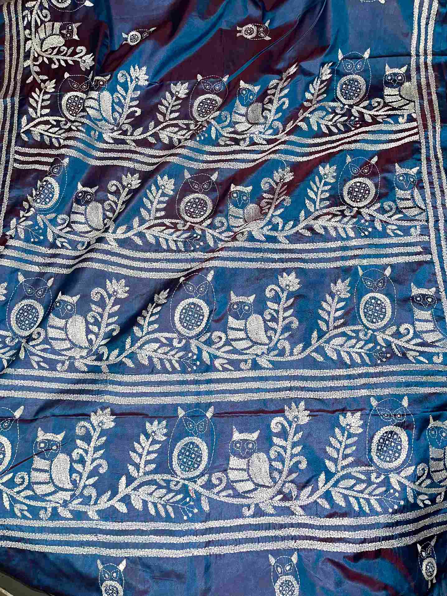Close-up of Kantha stitch owl motif on dual-tone Blue silk – traditional saree look by Desi Aadat