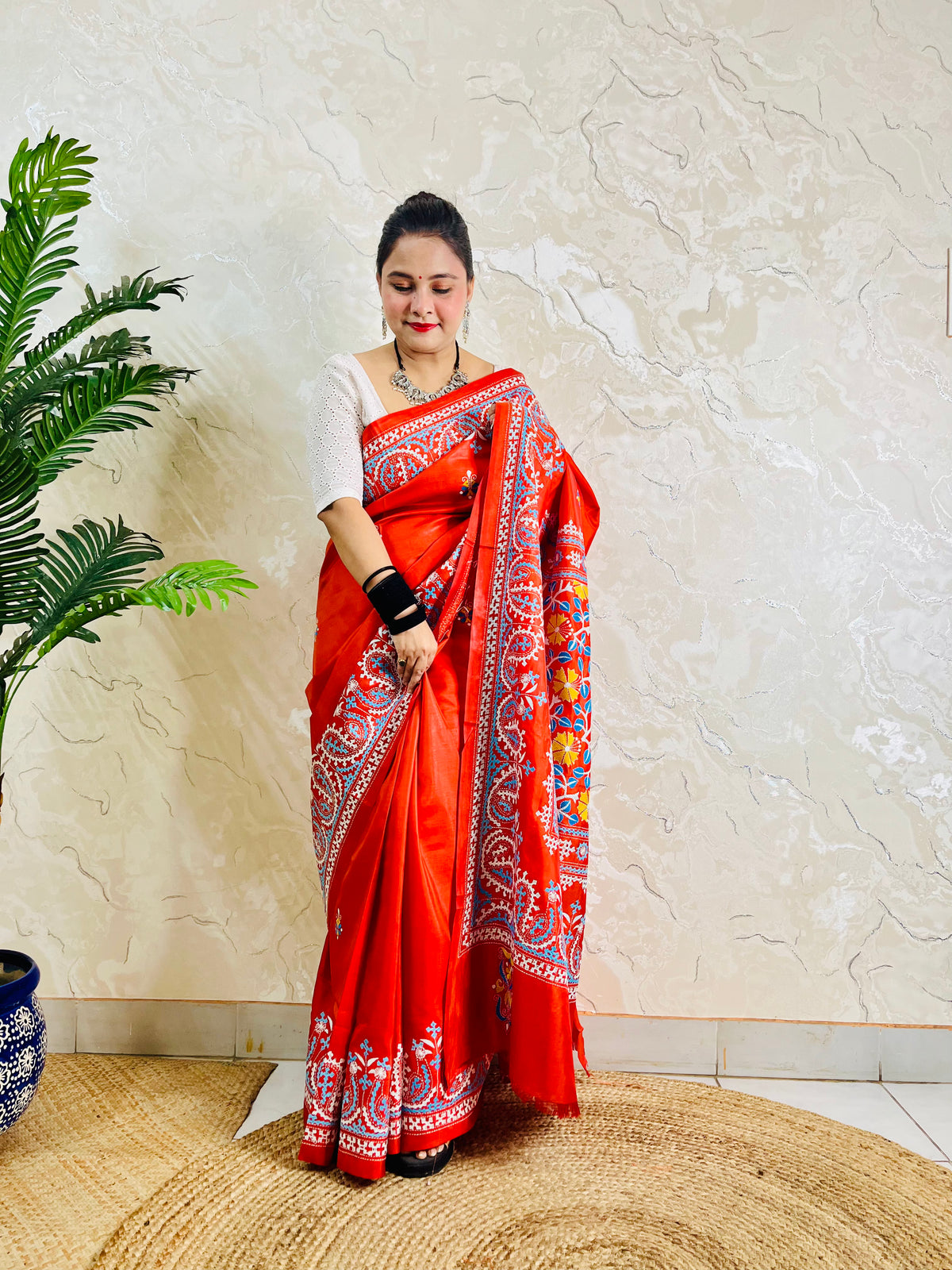 Front standing view of vermilion Kantha and Kutch work fusion saree on Bangalore silk with paisley pallu