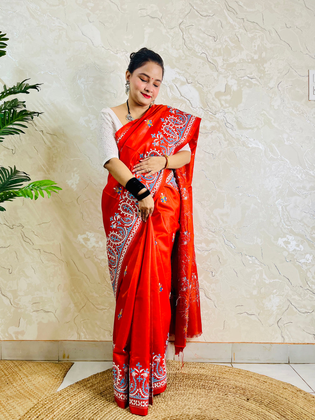 Front standing view of vermilion Kantha and Kutch work fusion saree on Bangalore silk with paisley pallu