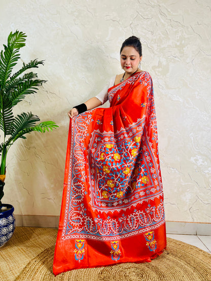 Pallu held open showing Kantha vine garden framed by Kutch cross-stitch paisley borders on vermilion silk
