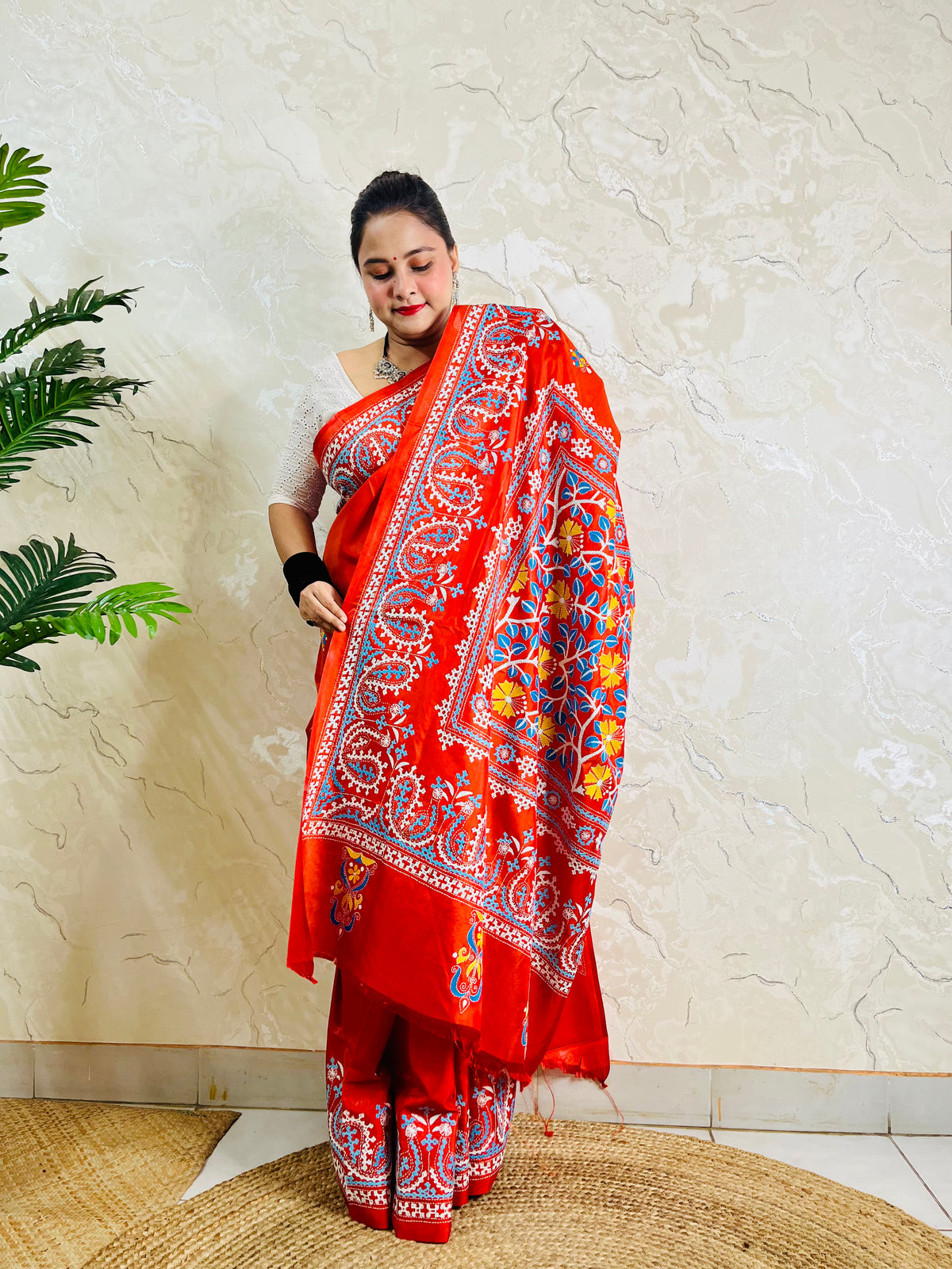 Front standing view of vermilion Kantha and Kutch work fusion saree on Bangalore silk with paisley pallu