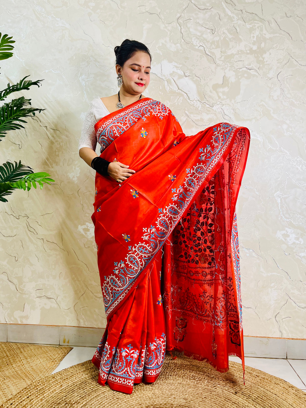 Front standing view of vermilion Kantha and Kutch work fusion saree on Bangalore silk with paisley pallu