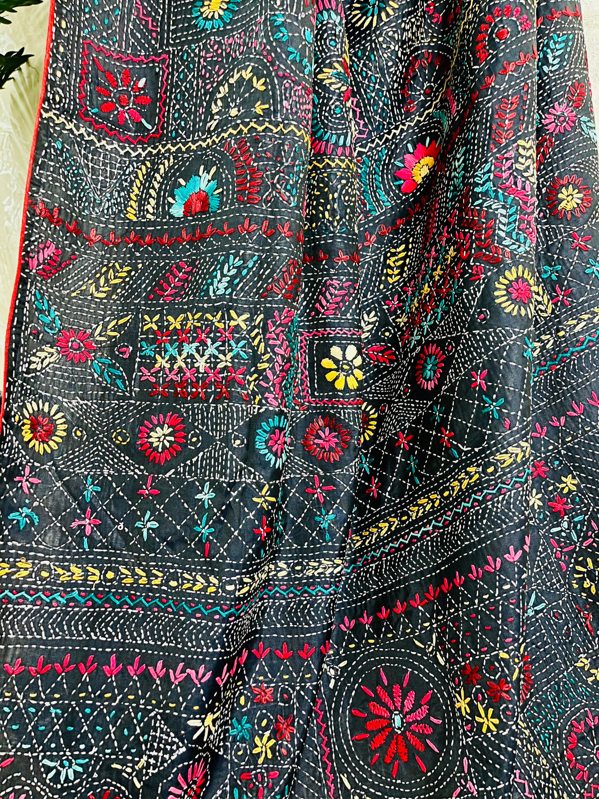Detailed view of colourful Lambani thread work on black saree fabric