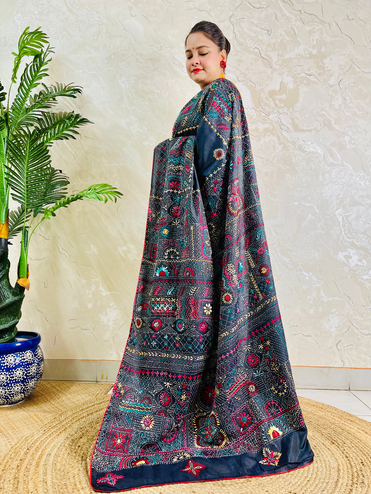 Black Lambani embroidered saree with red border, side standing view