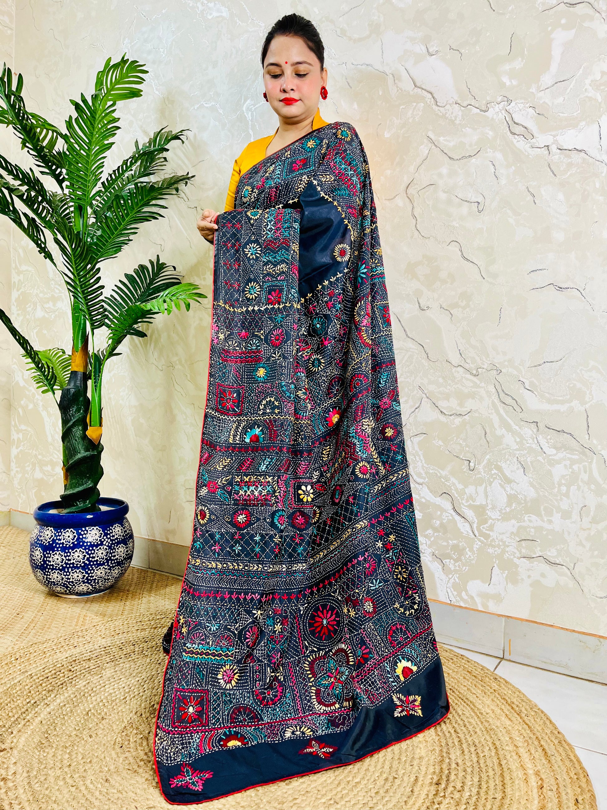 Black Lambani embroidered saree with red border, side standing view