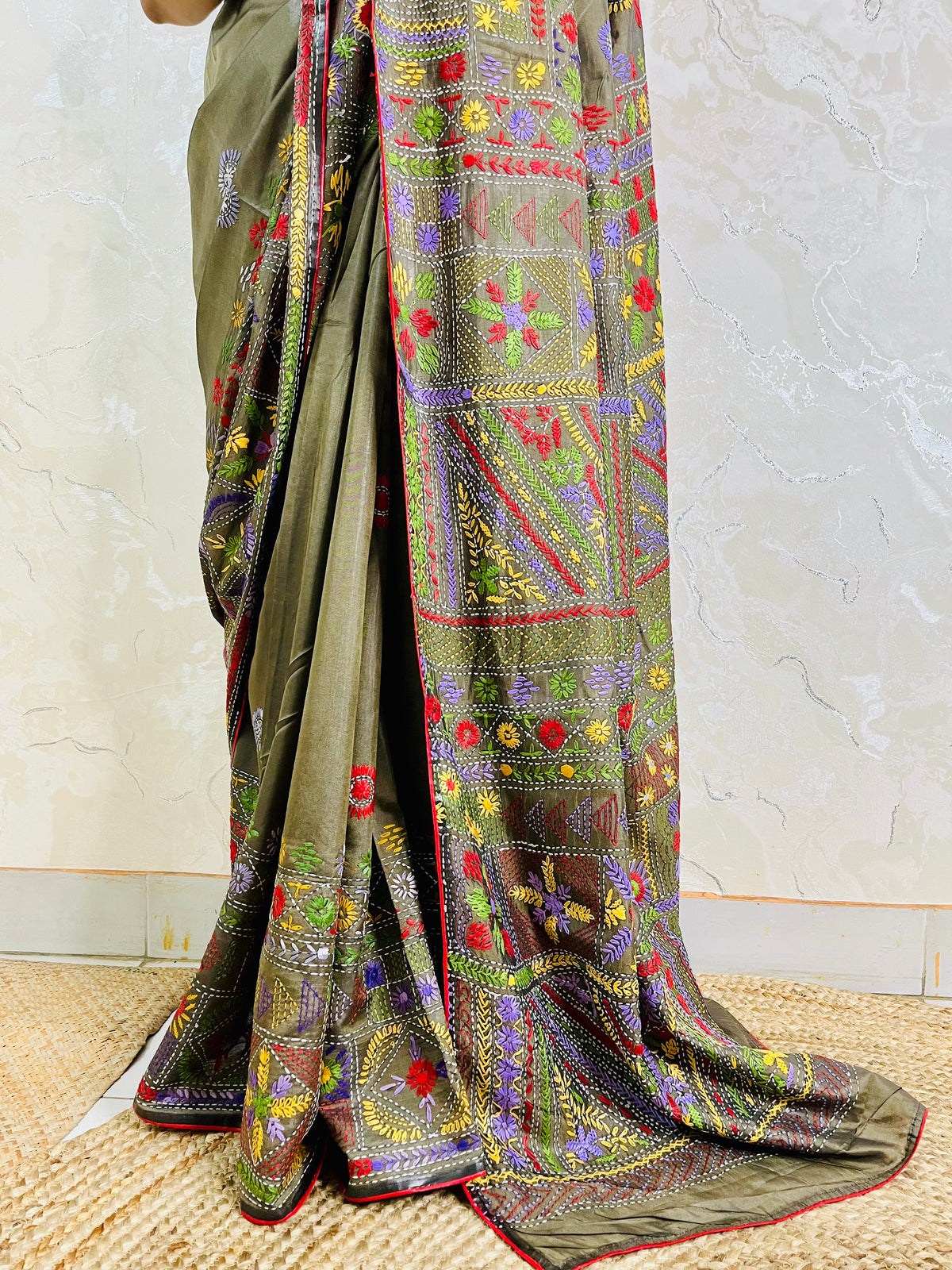 Close-up of dense floral Lambani hand stitch embroidery on moss green silk
