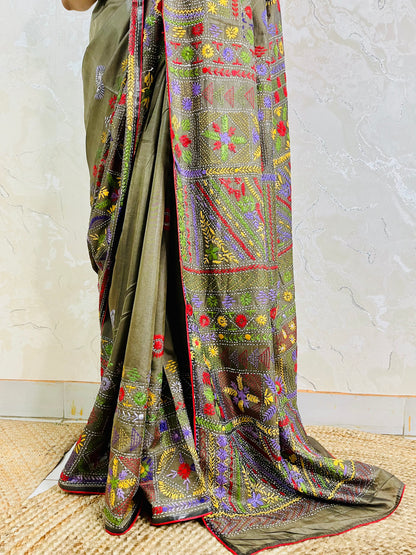 Close-up of dense floral Lambani hand stitch embroidery on moss green silk