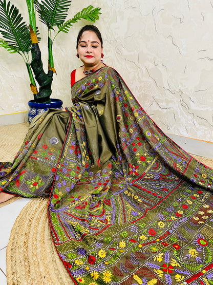 Front seated view of moss green Lambani stitch saree with floral border