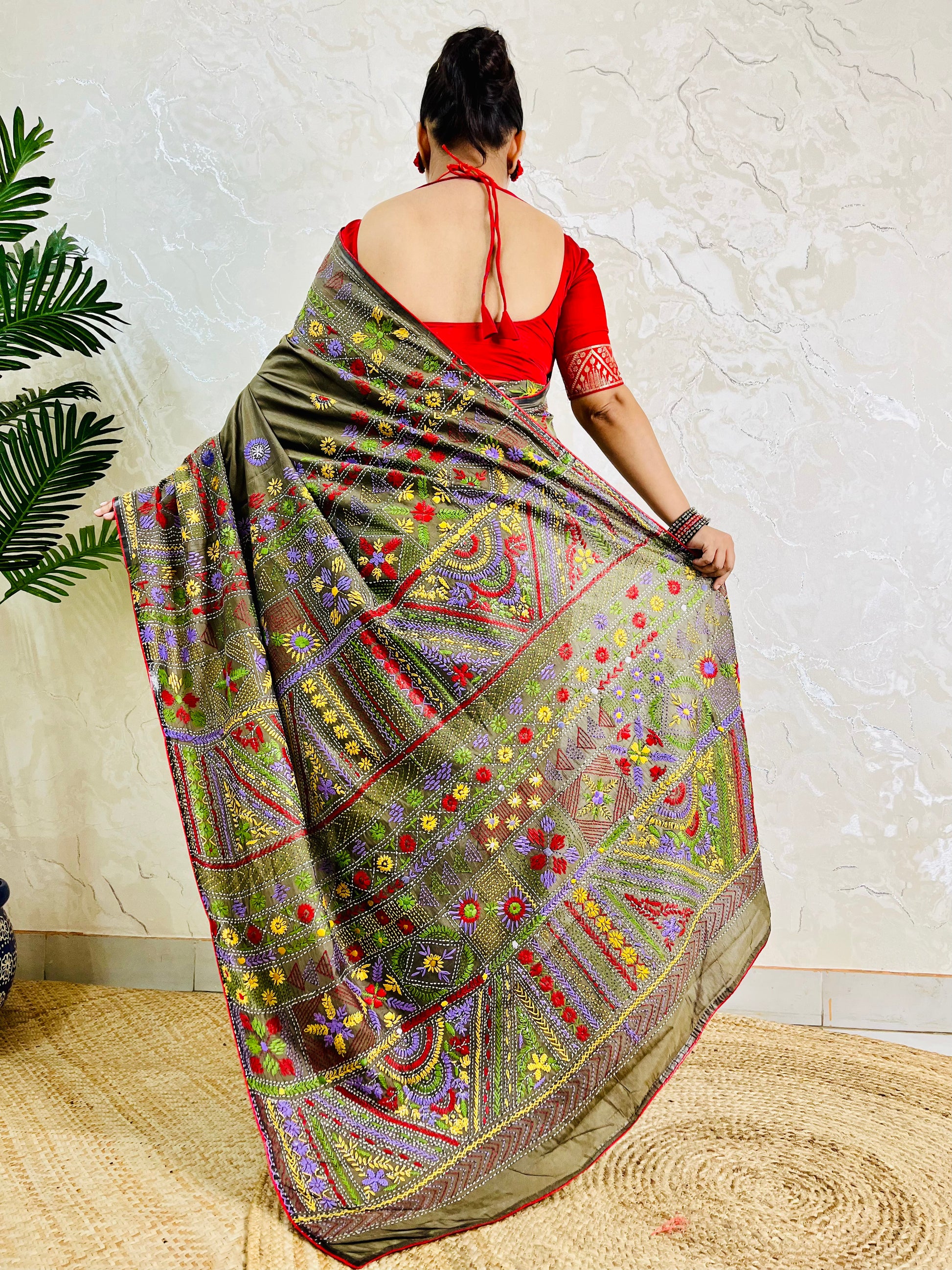 Back standing view of moss green Lambani hand embroidered saree