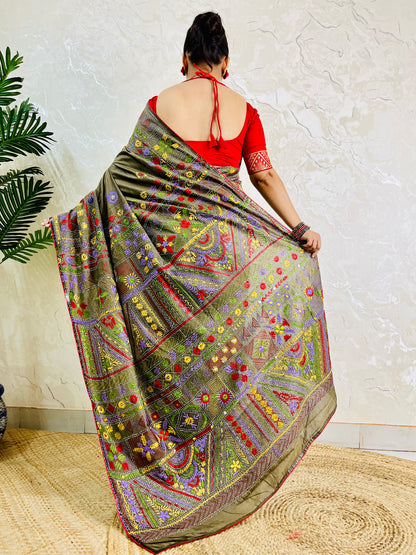 Back standing view of moss green Lambani hand embroidered saree