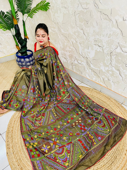 Front seated view of moss green Lambani stitch saree with floral border