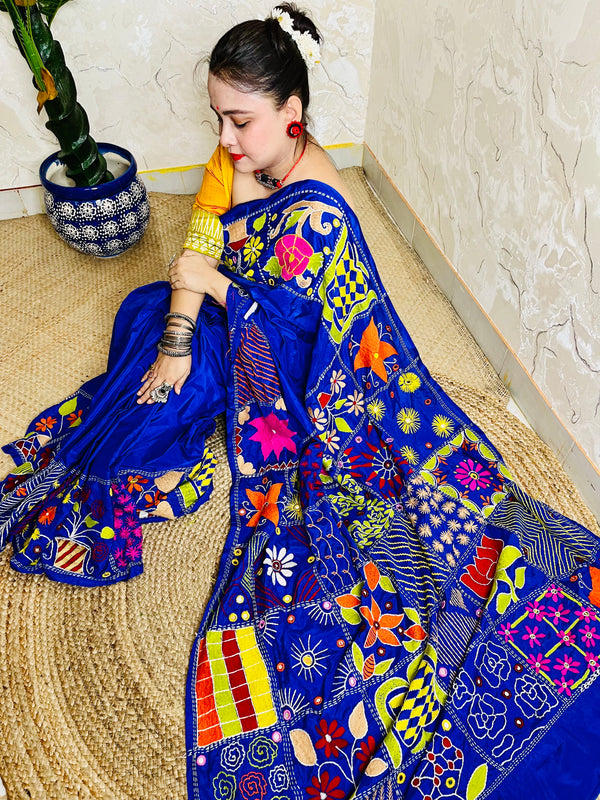 Woman wearing blue silk saree with traditional Lambani hand embroidery design