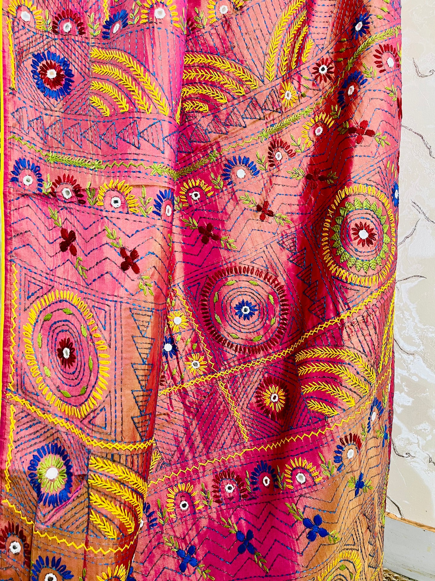 Close-up of Lambani hand embroidery mandala motif in coral pink saree