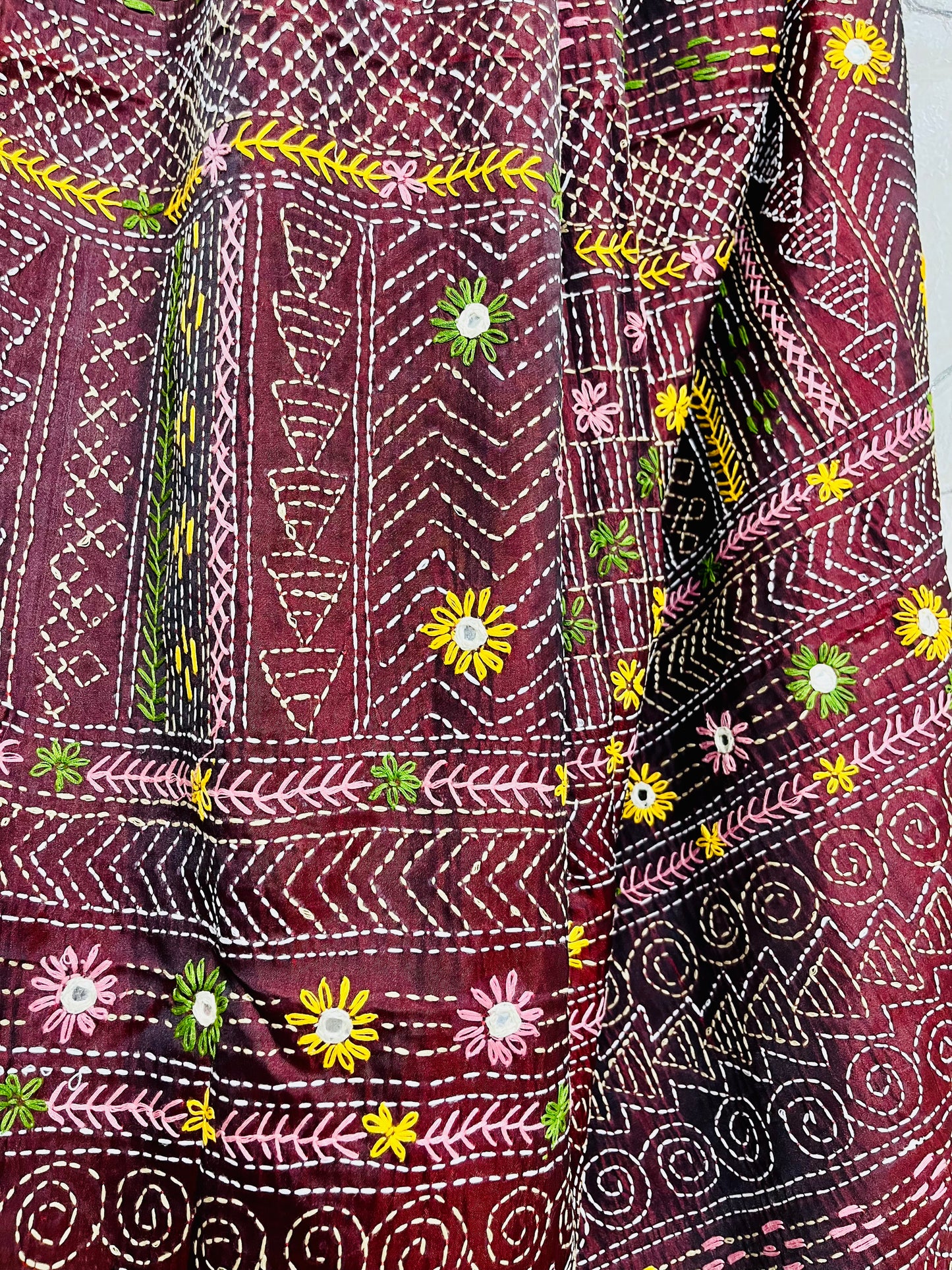 Close-up of mica mirror work and Lambani hand stitch embroidery on burgundy silk saree