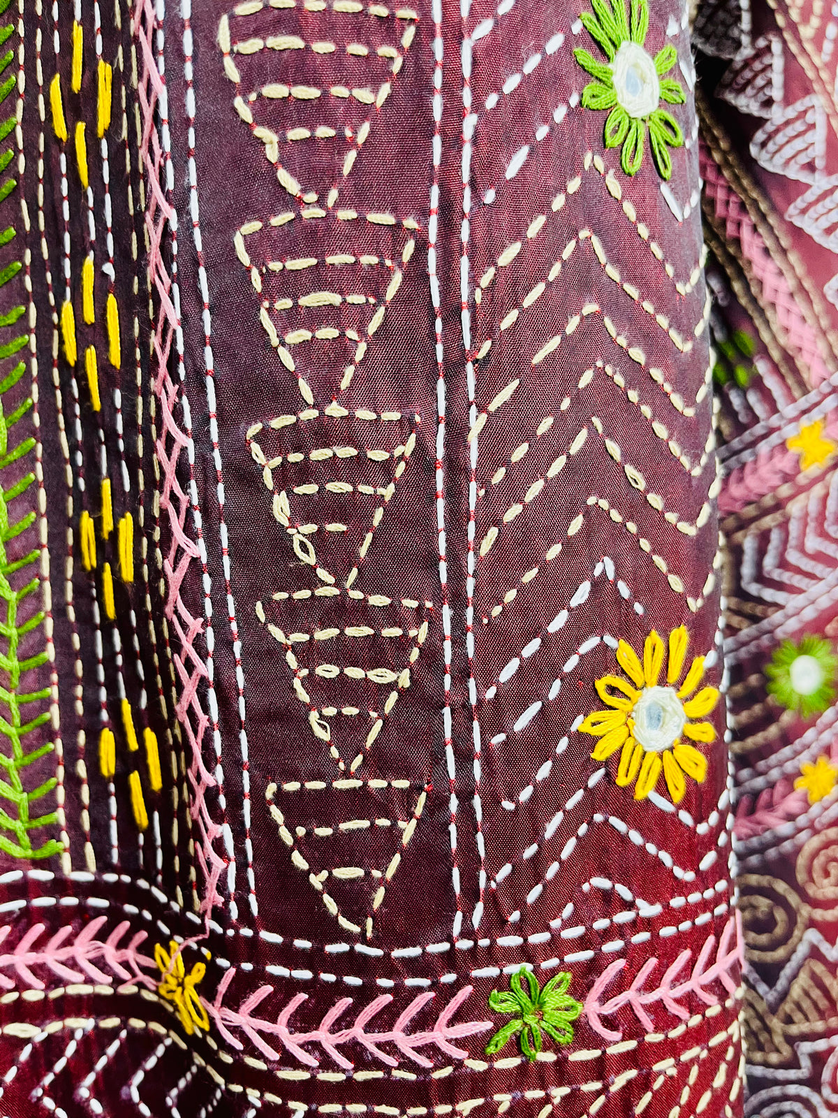 Close-up of mica mirror work and Lambani hand stitch embroidery on burgundy silk saree