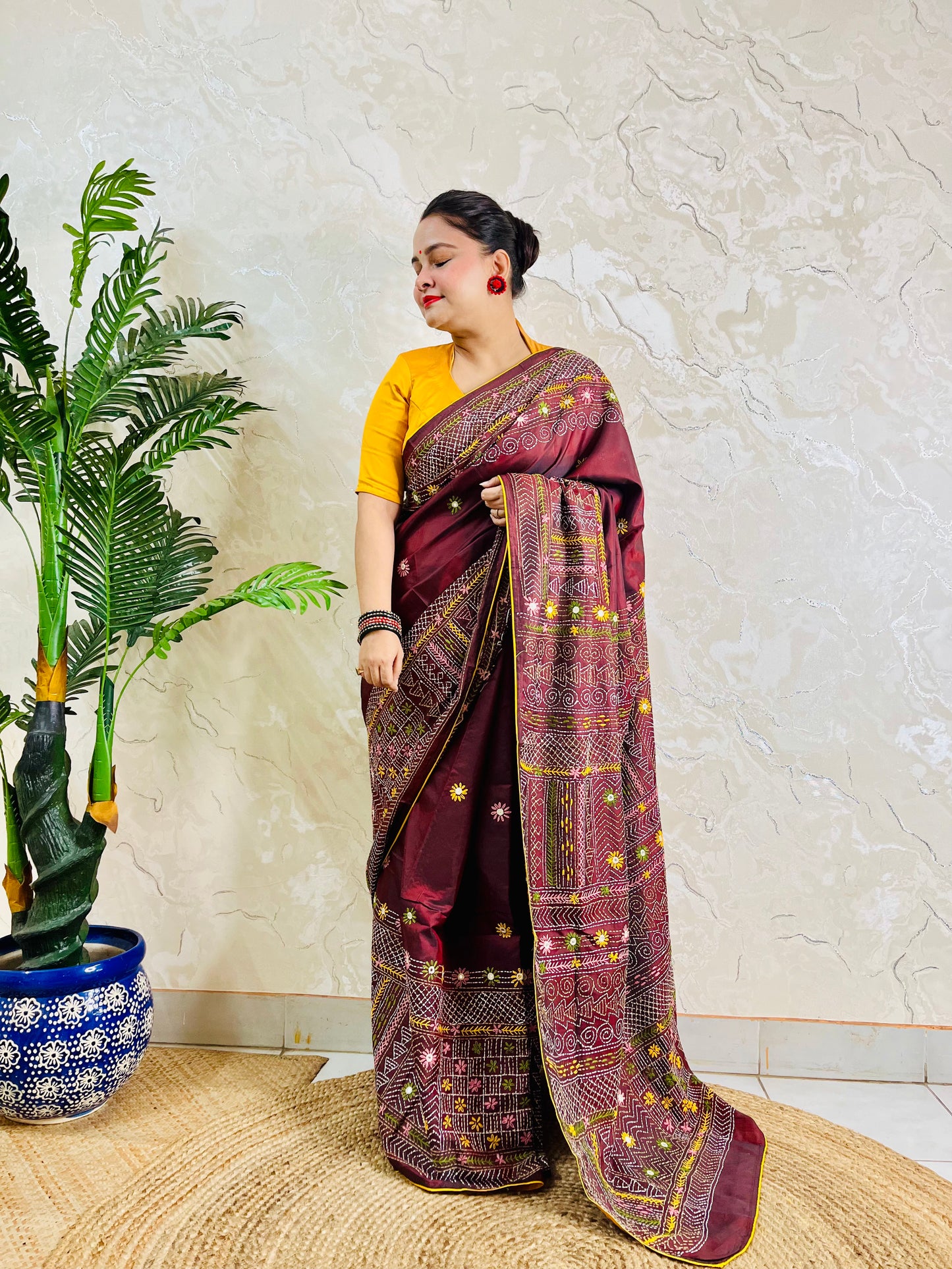 Woman wearing burgundy Bangalore silk saree with Lambani hand embroidery, side standing