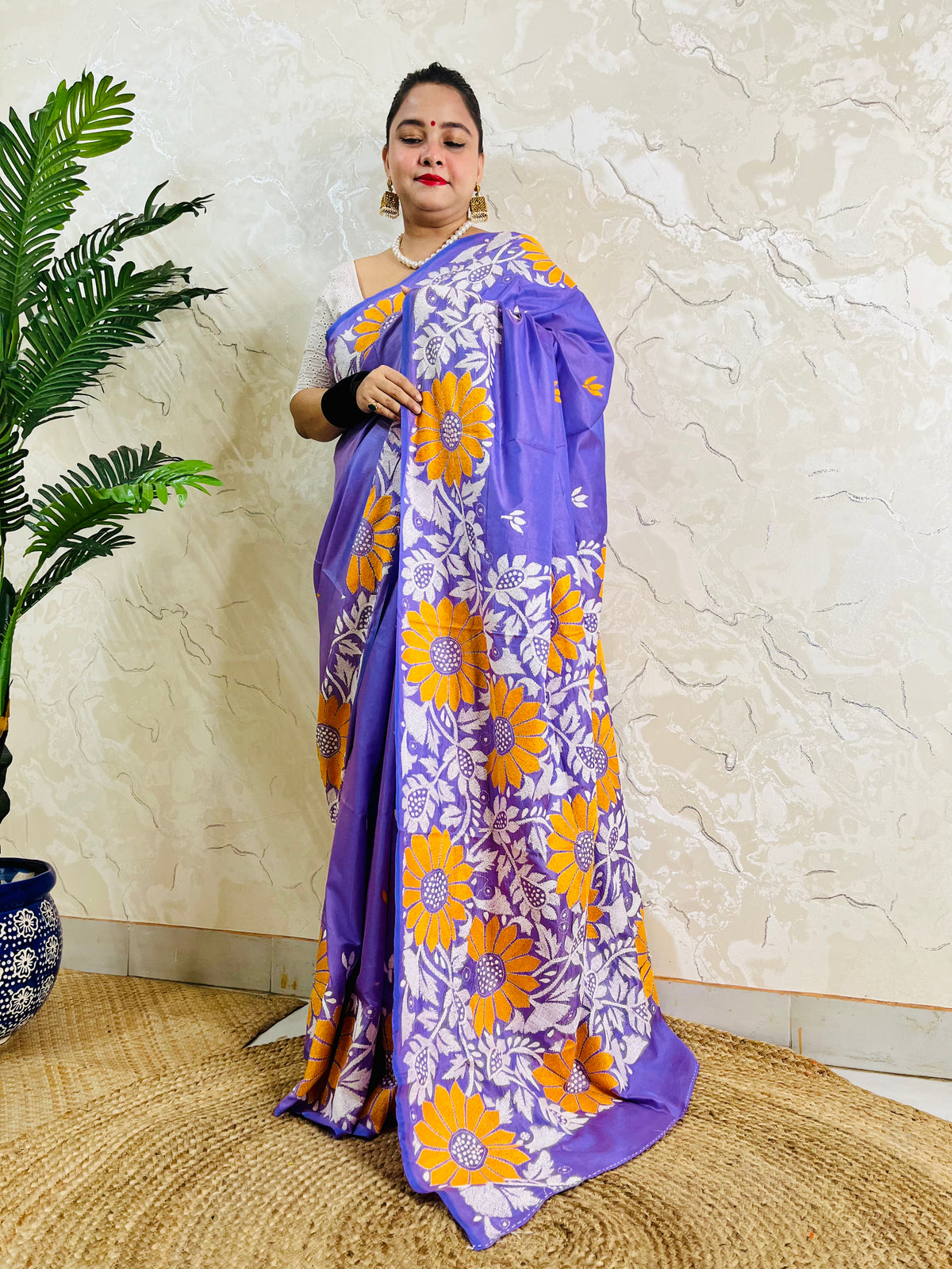 Front standing portrait of a model draped in the handcrafted lavender violet saree, showcasing the flowing sunflower motif pallu.