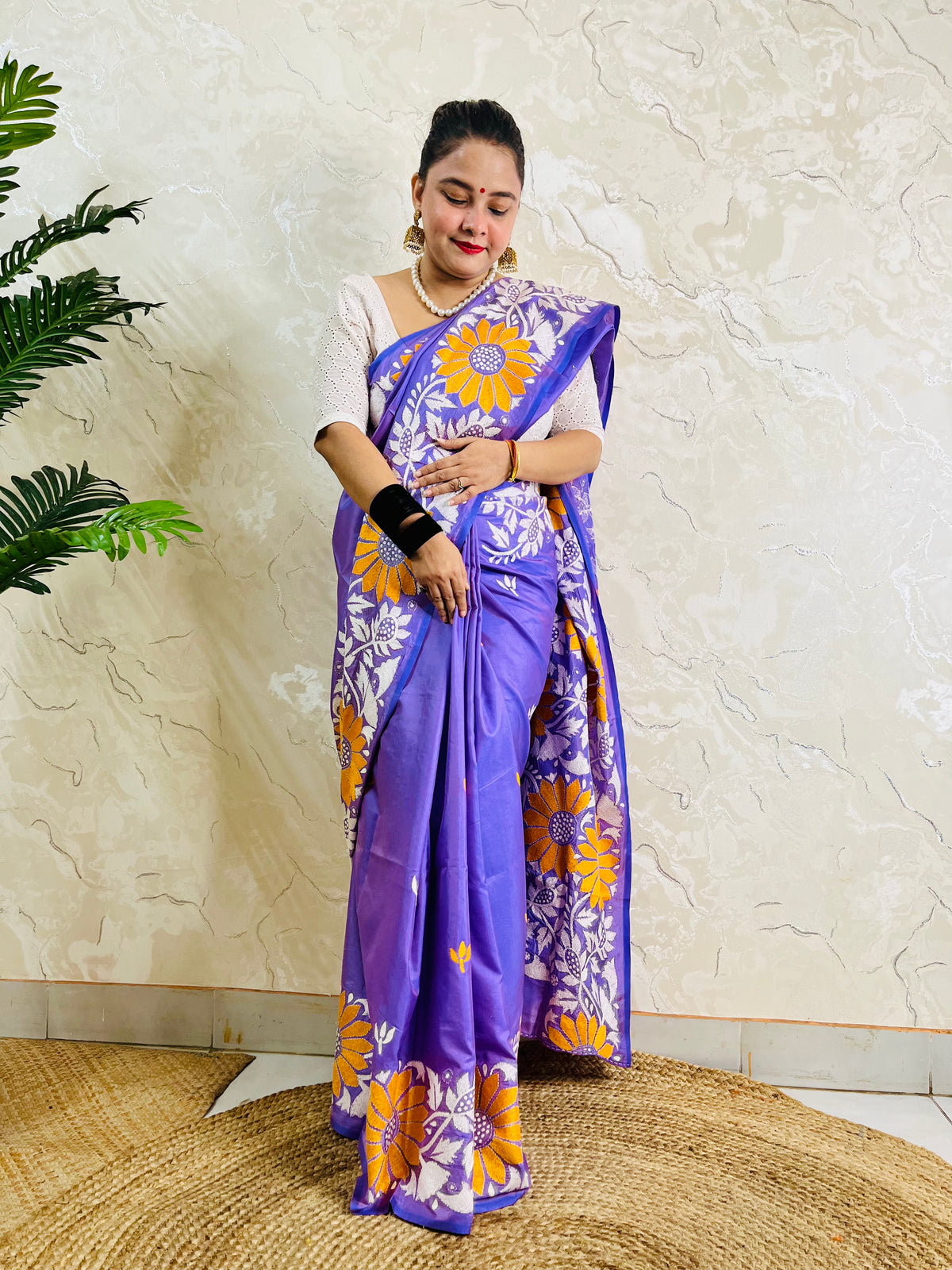 Front standing portrait of a model draped in the handcrafted lavender violet saree, showcasing the flowing sunflower motif pallu.
