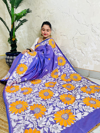 High-angle sitting view of the spread-out lavender violet saree, showcasing the intricate white leaf vines and vibrant golden sunflower embroidery.