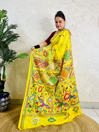 Front view of a woman elegantly modeling the exclusive handmade yellow Nakshi Katha traditional saree, displaying the vibrant, unreplicable ethnic thread work