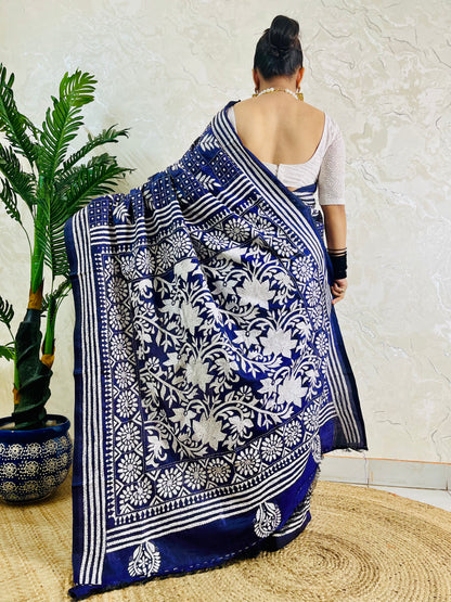 Rear view displaying the drape of the navy blue handwoven traditional saree and the contrast white Katha stitch patterns across the back