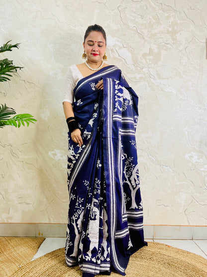 Full front view of model wearing the navy blue Santhal village scene silk saree, displaying the tribal motif pleats and multi-line border.