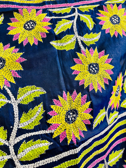 Close-up of yellow sunflower Kantha running stitch embroidery with lime leaves on navy blue silk