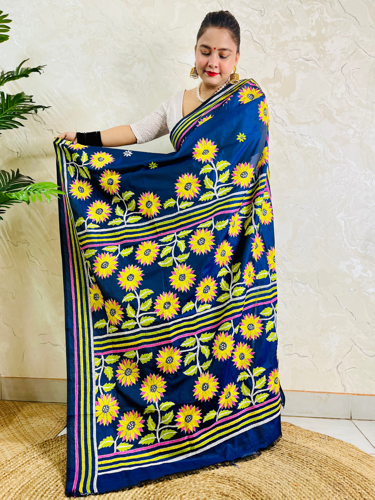 Pallu held open showing rows of hand embroidered sunflowers framed by lime, yellow and pink stripes