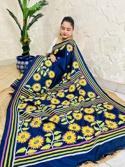 Seated drape of navy blue Kantha stitch saree with yellow sunflower motifs and scattered small flowers