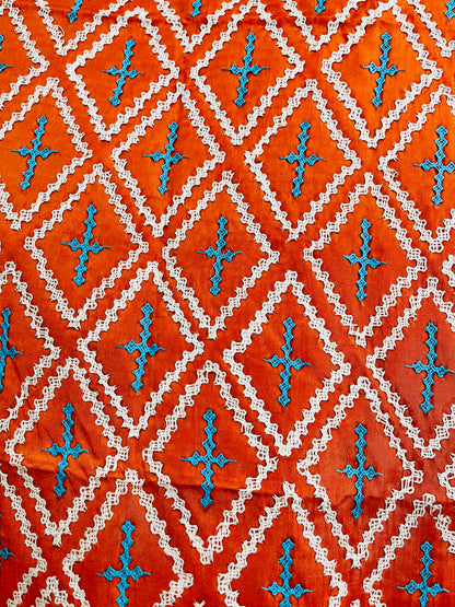 Close-up of orange saree showing kairi paisley border with Kutch cross-stitch