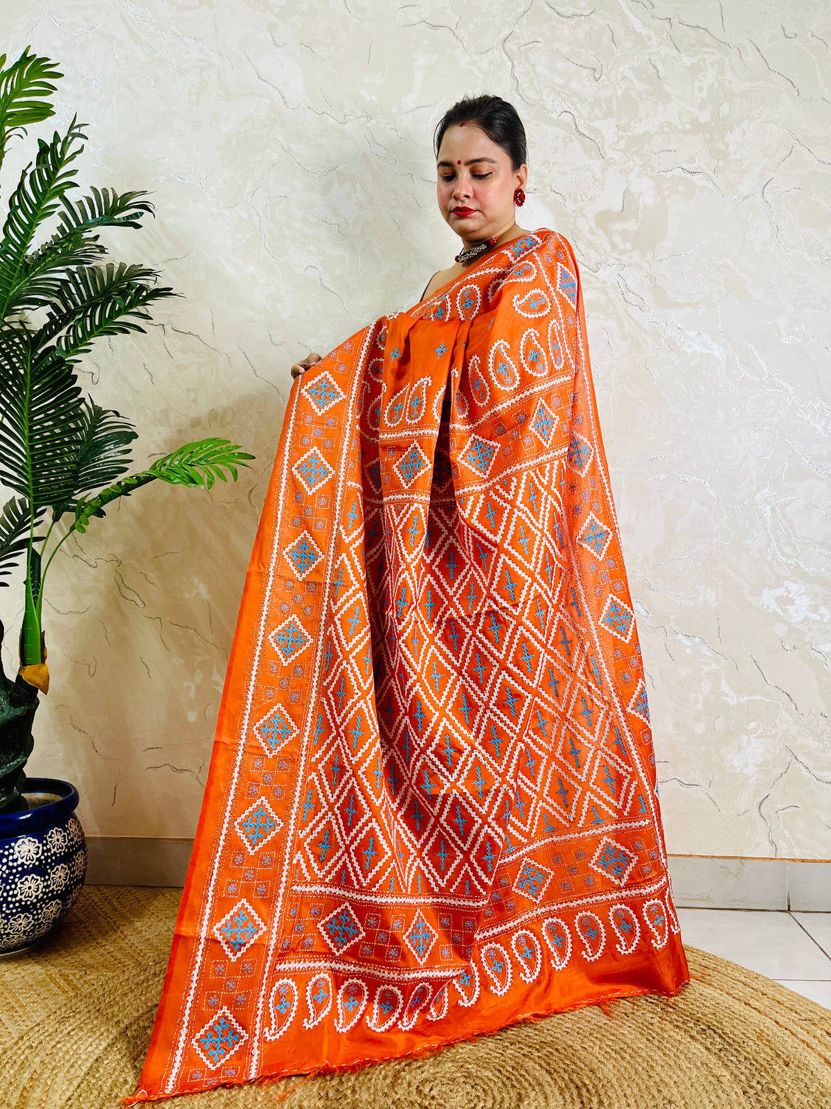Macro detail of orange saree diamond lattice embroidery in white and sky blue