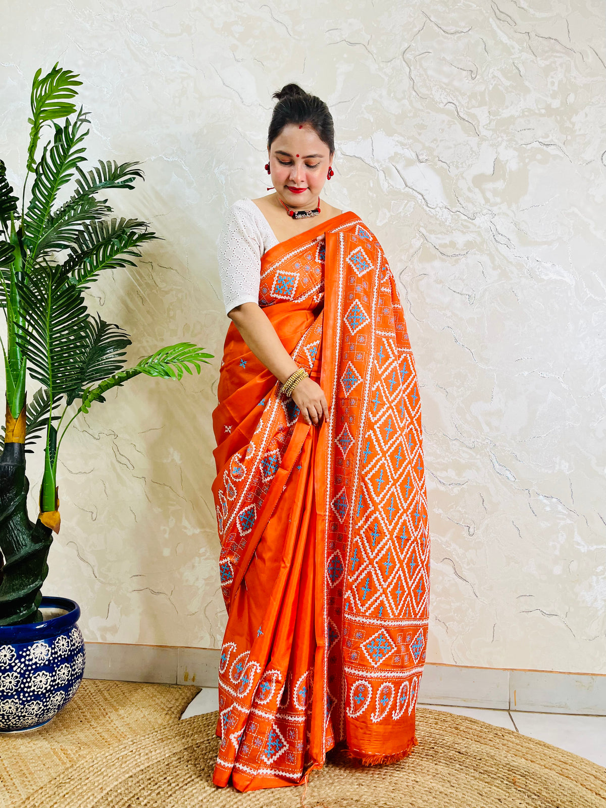Orange handwoven silk saree with white and blue diamond embroidery pattern