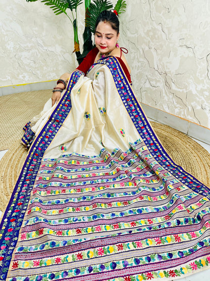 Handwoven Parsi Gara Semi Muga Silk saree with dense multicolour horizontal floral garden stripes pallu and royal blue velvet Kardana border — sitting view, Desi Aadat