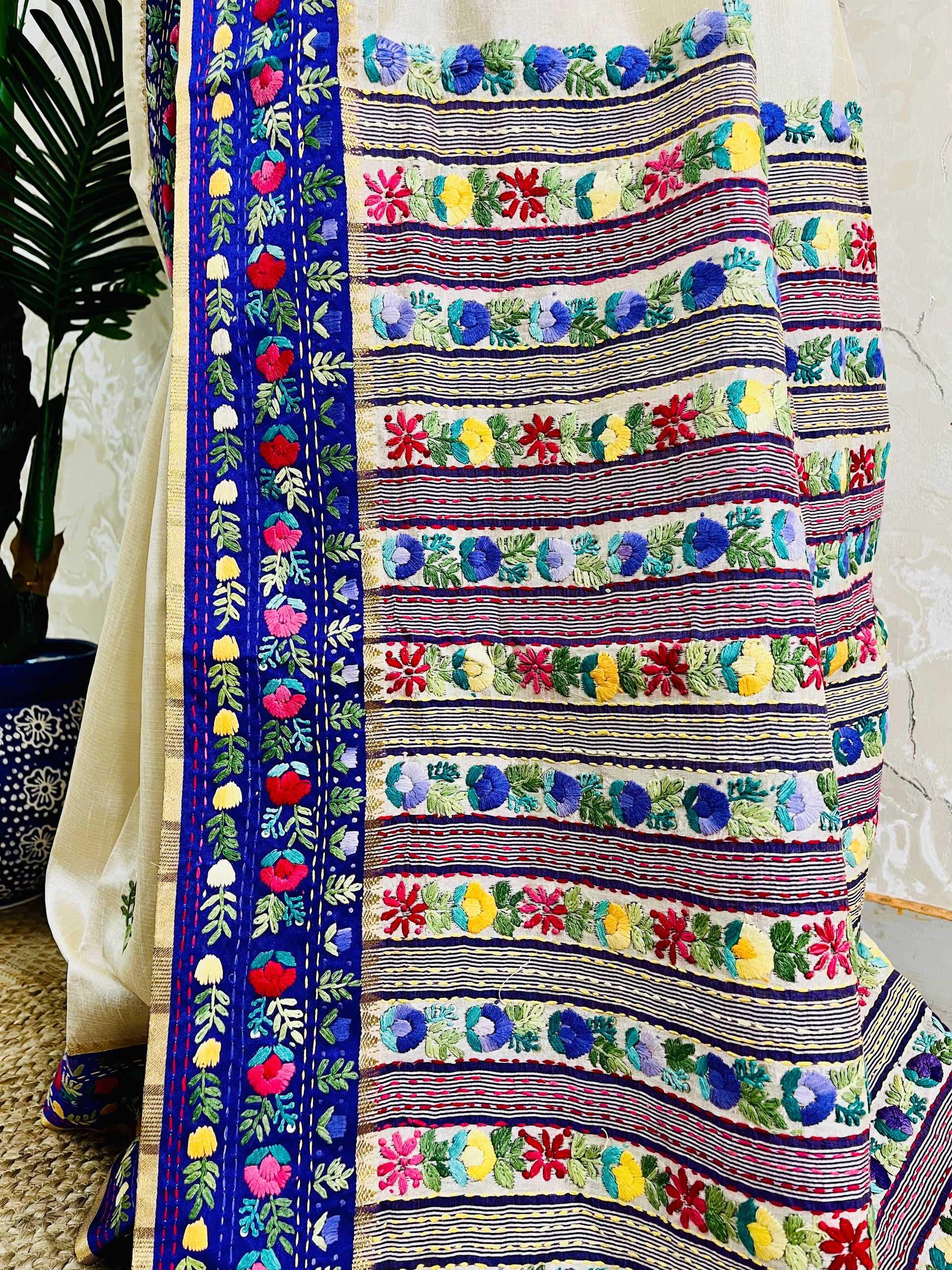 Close-up of Parsi Gara hand-embroidered horizontal floral garden stripes with multicolour blooms and Kardana embellishment on Semi Muga Silk pallu with royal blue velvet border — Desi Aadat