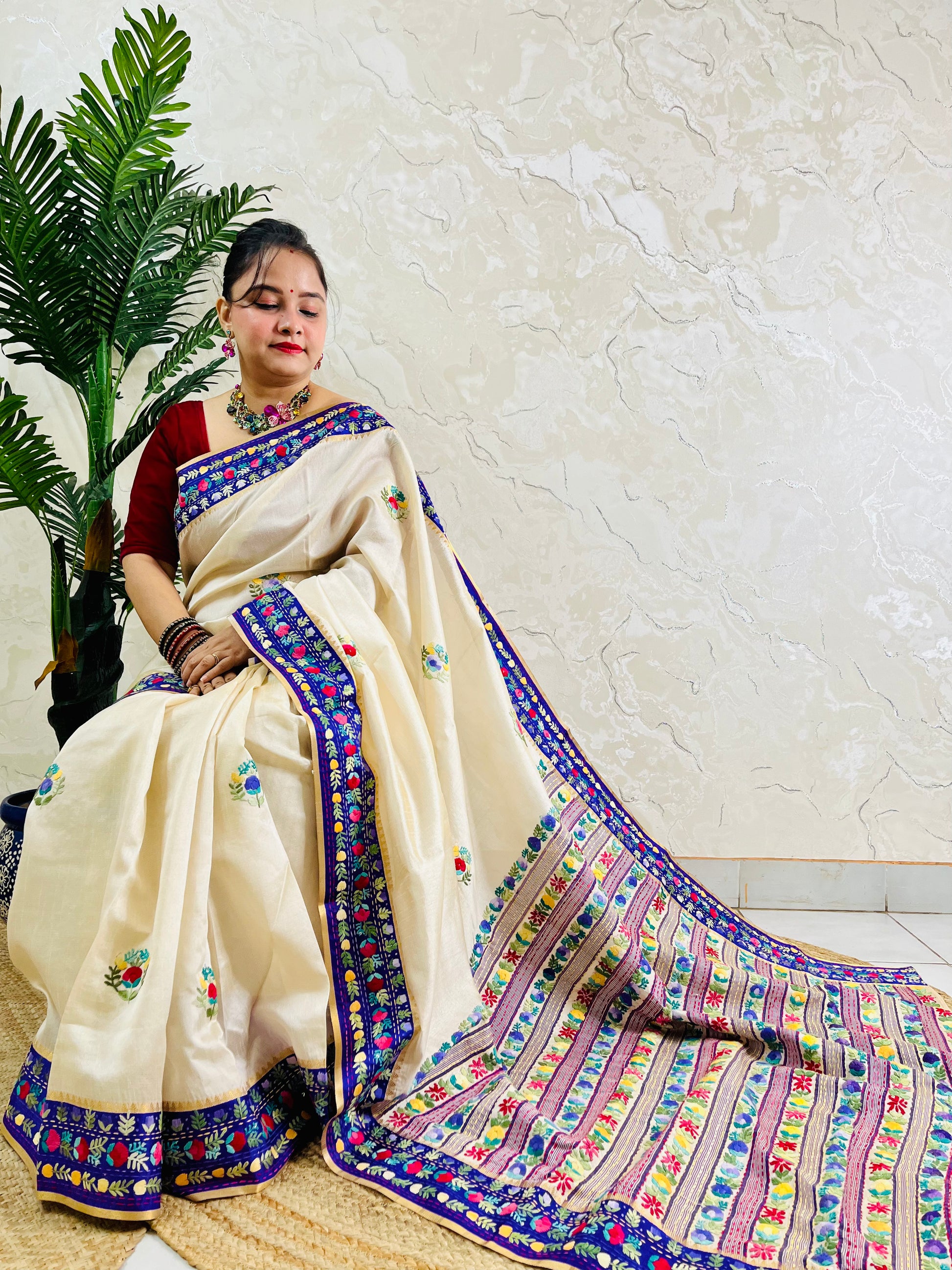 Handwoven Parsi Gara Semi Muga Silk saree with dense multicolour horizontal floral garden stripes pallu and royal blue velvet Kardana border — sitting view, Desi Aadat