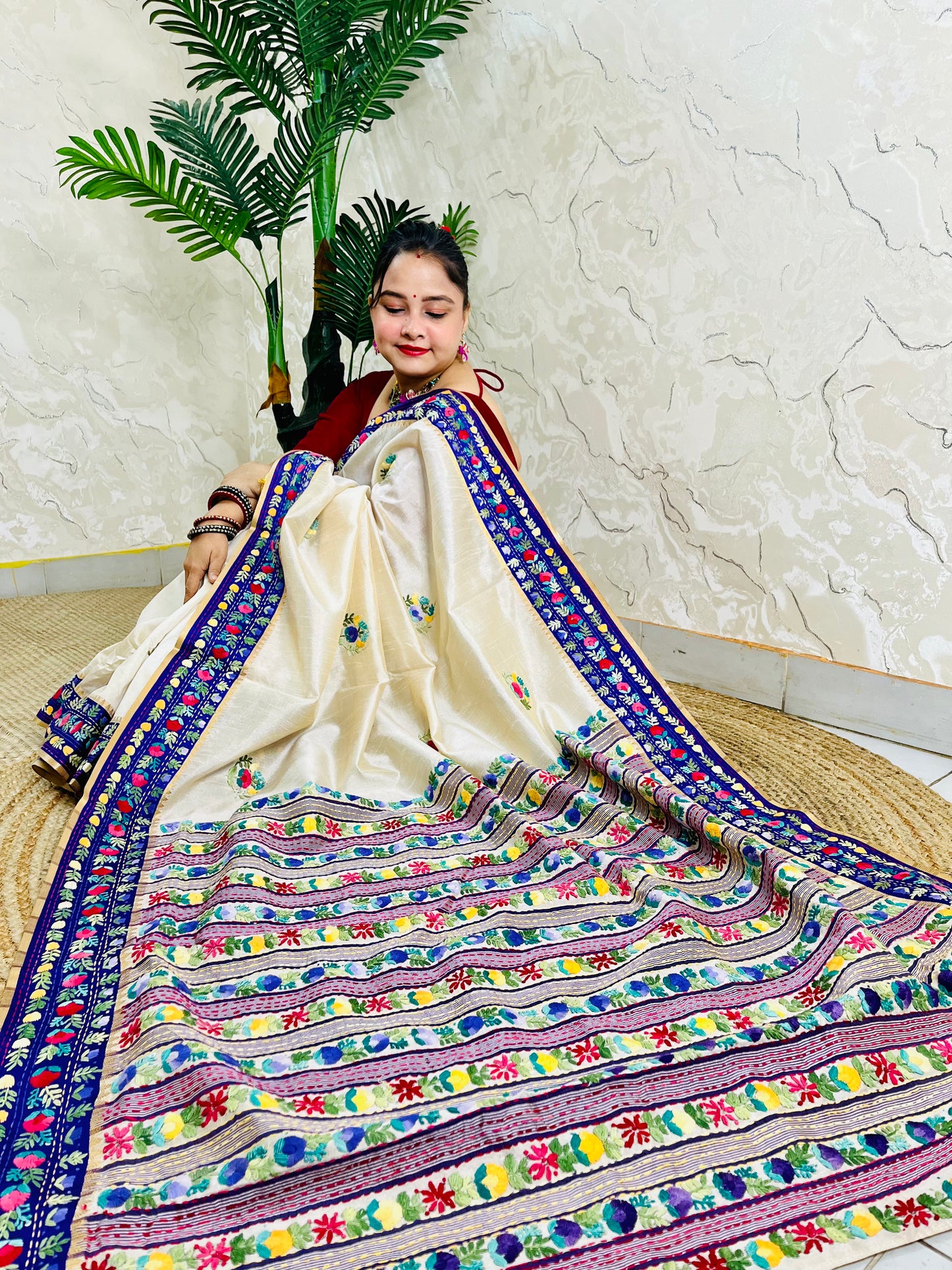 Handwoven Parsi Gara Semi Muga Silk saree with dense multicolour horizontal floral garden stripes pallu and royal blue velvet Kardana border — sitting view, Desi Aadat