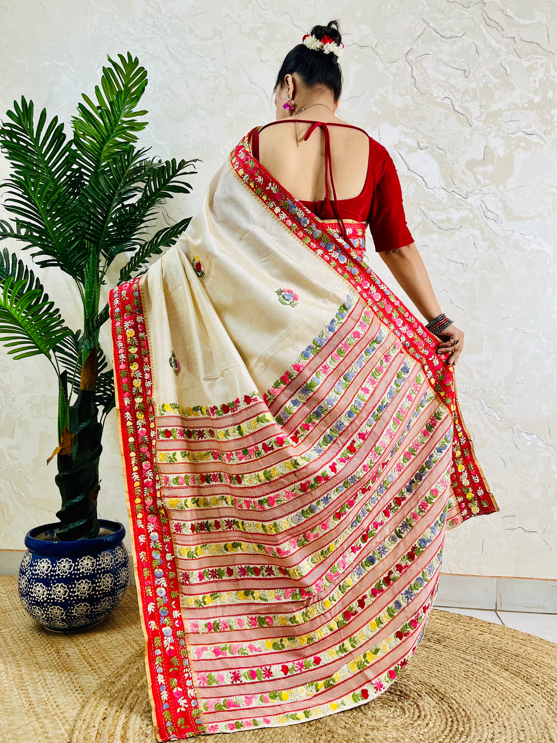 Front standing view of Parsi Gara handwoven Semi Muga Silk saree with red velvet border and multicolour floral embroidery — heirloom saree by Desi Aadat